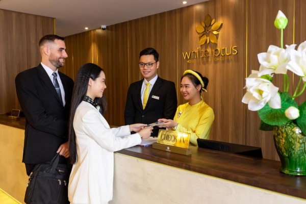 Khách đang làm thủ tục check-in tại quầy lễ tân sang trọng